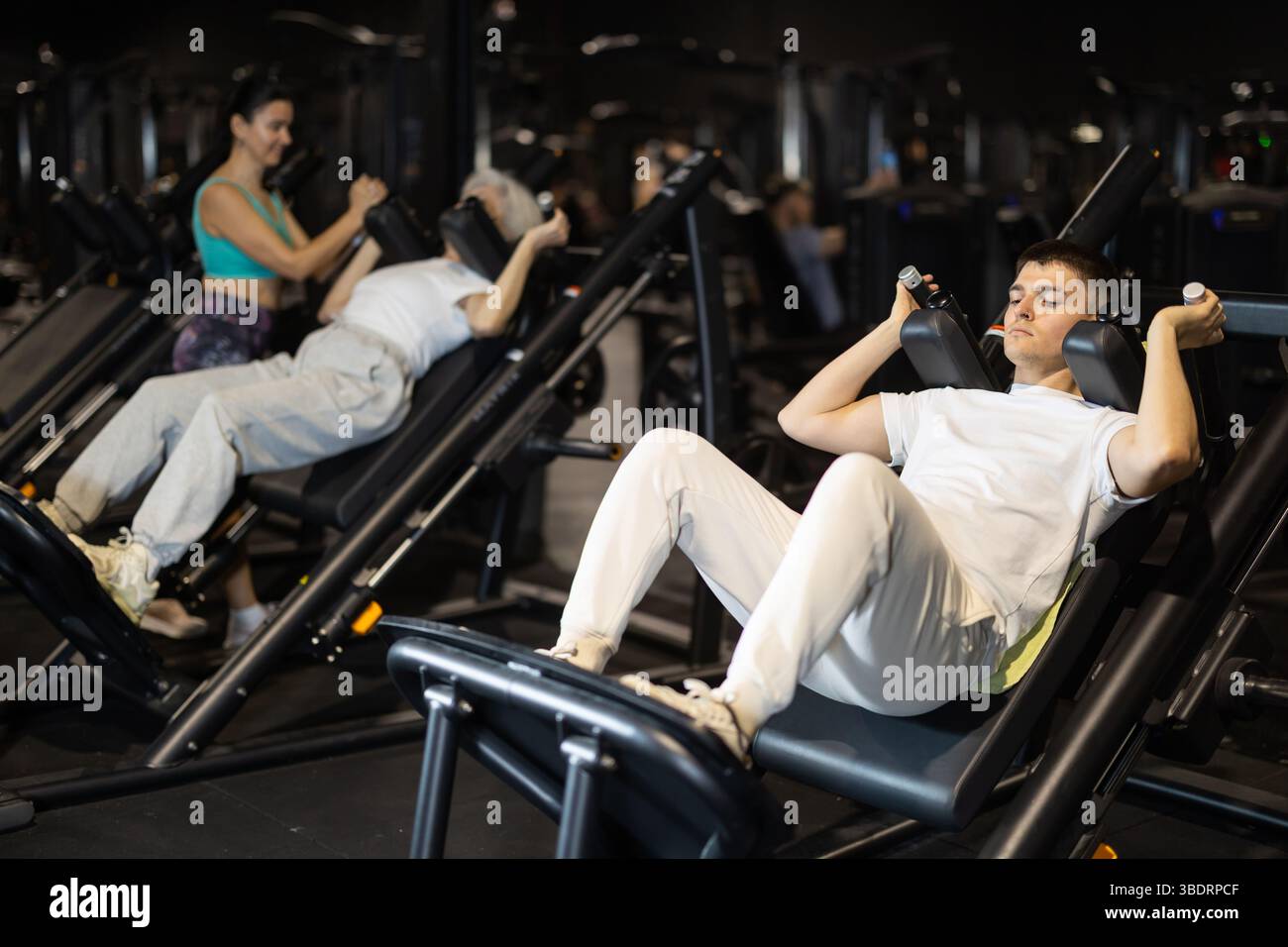 Guy uses hack squat machine to strengthen muscles Stock Photo - Alamy