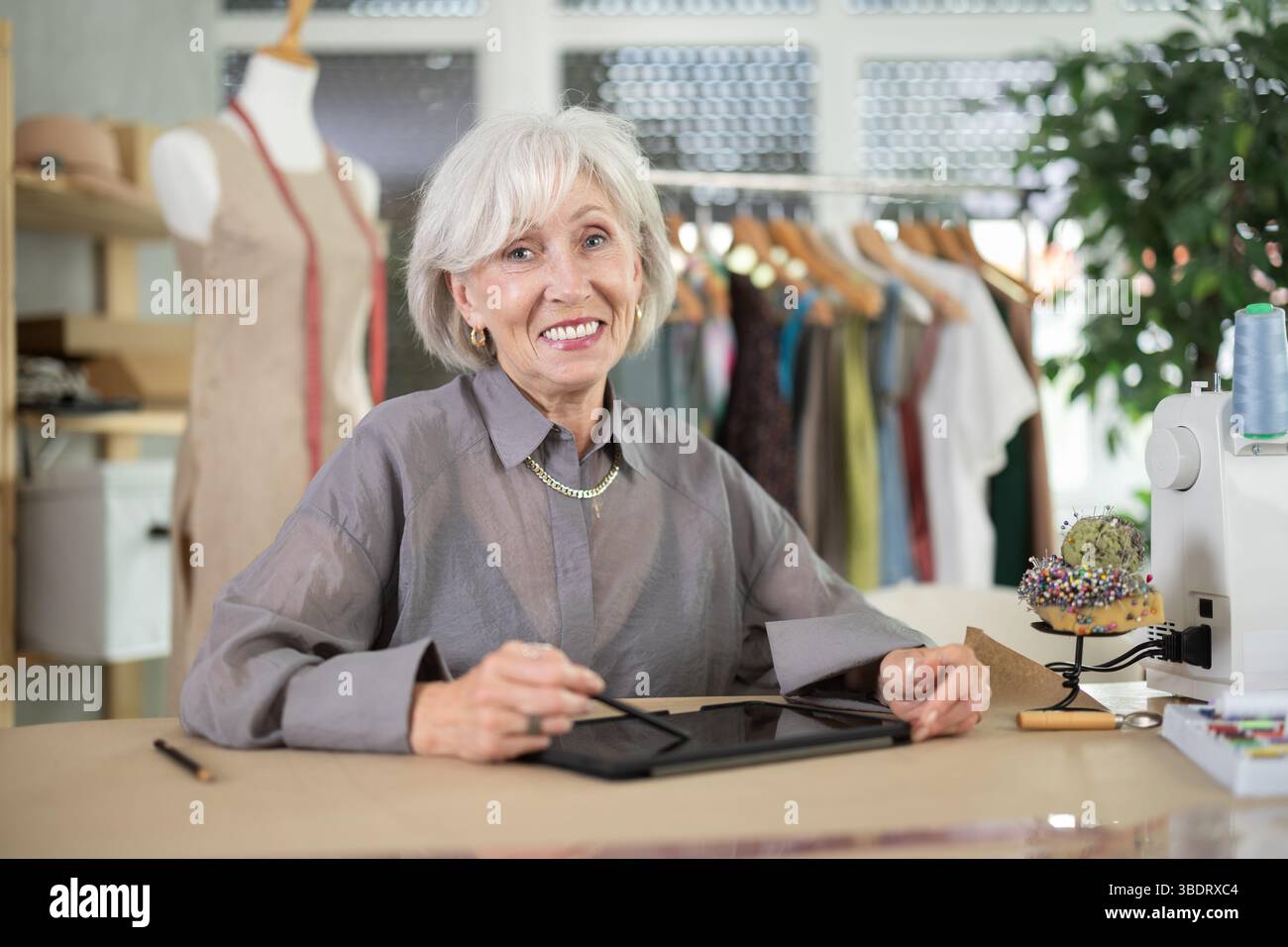 Woman dressmaker makes pattern using tablet Stock Photo