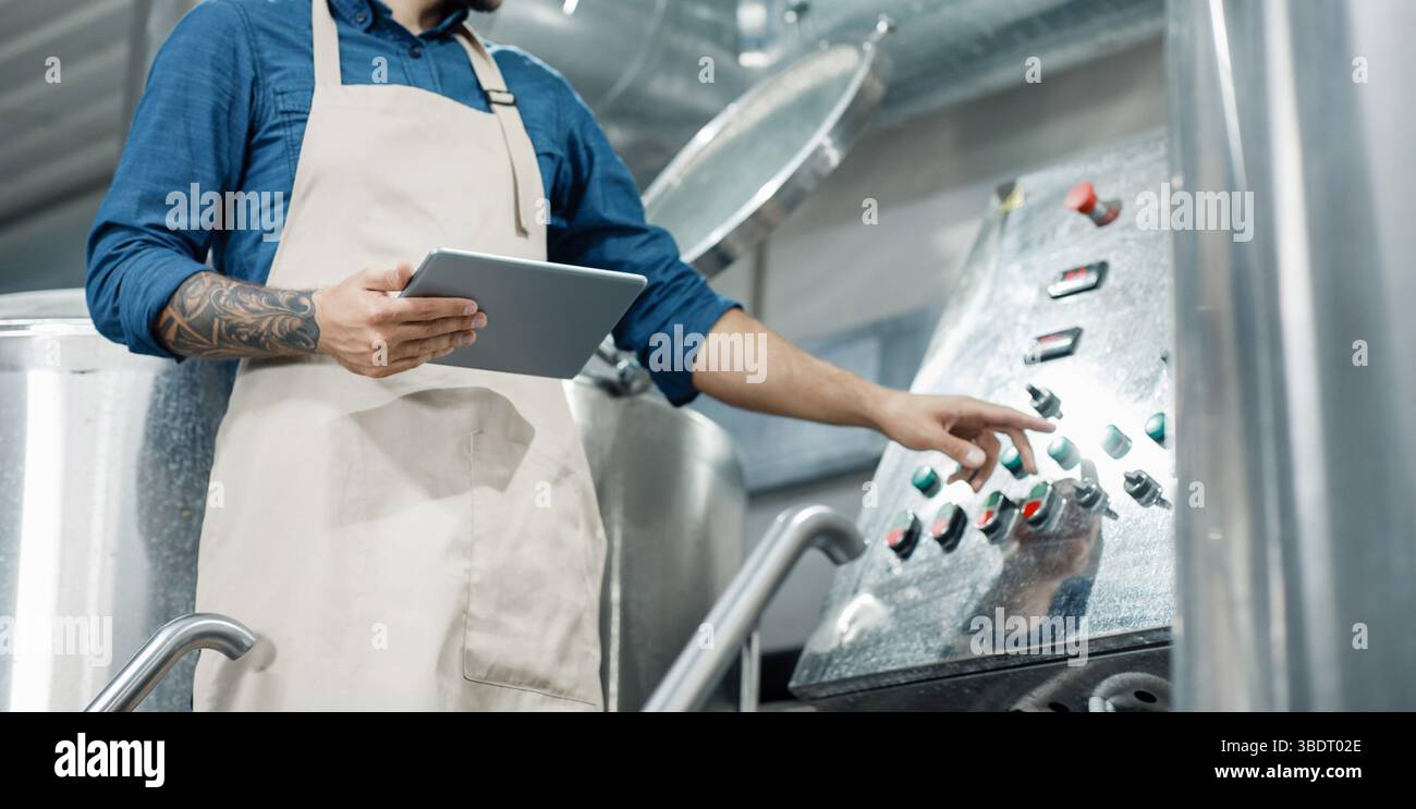 Male worker on beer factory, management and mobile app Stock Photo