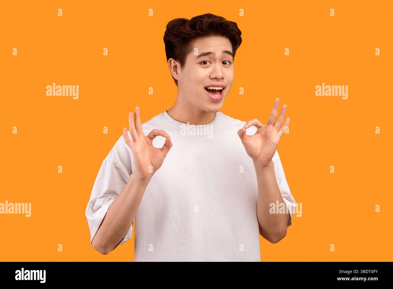 Happy asian young man gesturing okay and smiling Stock Photo