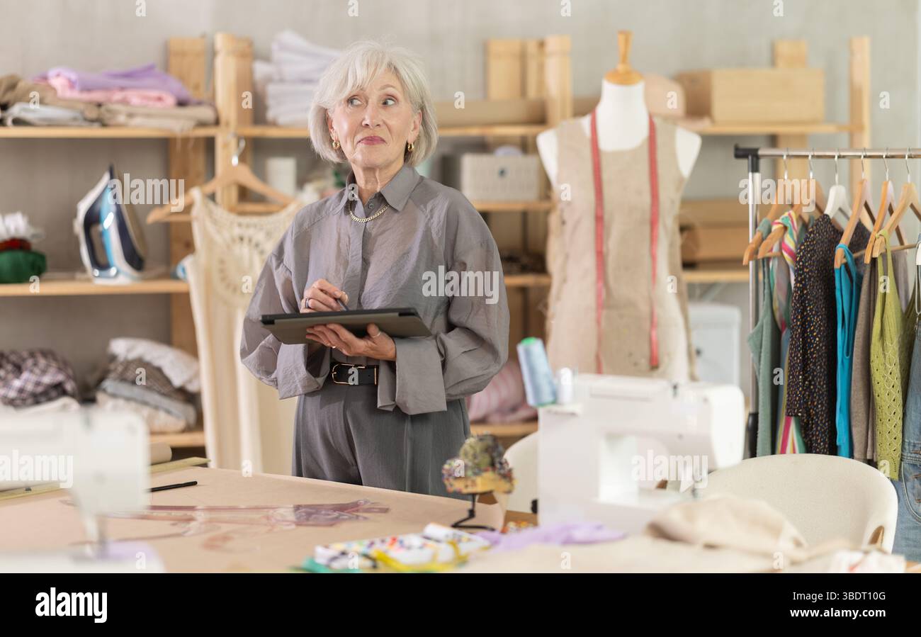 Woman dressmaker makes pattern using tablet Stock Photo
