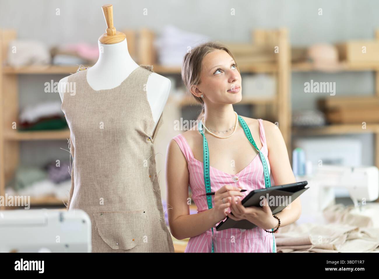 Woman dressmaker makes pattern using tablet Stock Photo