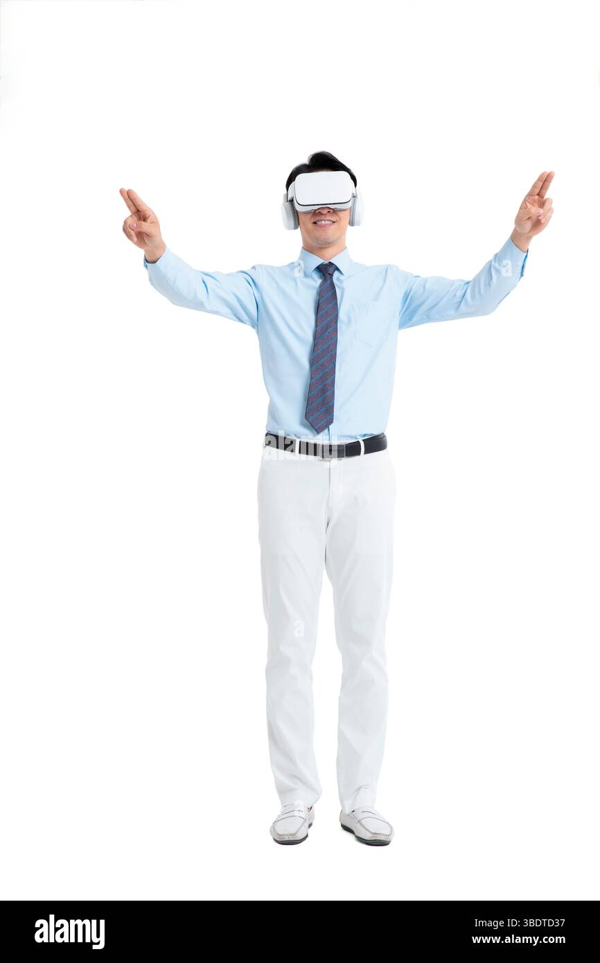 A suited man wearing a VR headset waves both hands vigorously Stock Photo