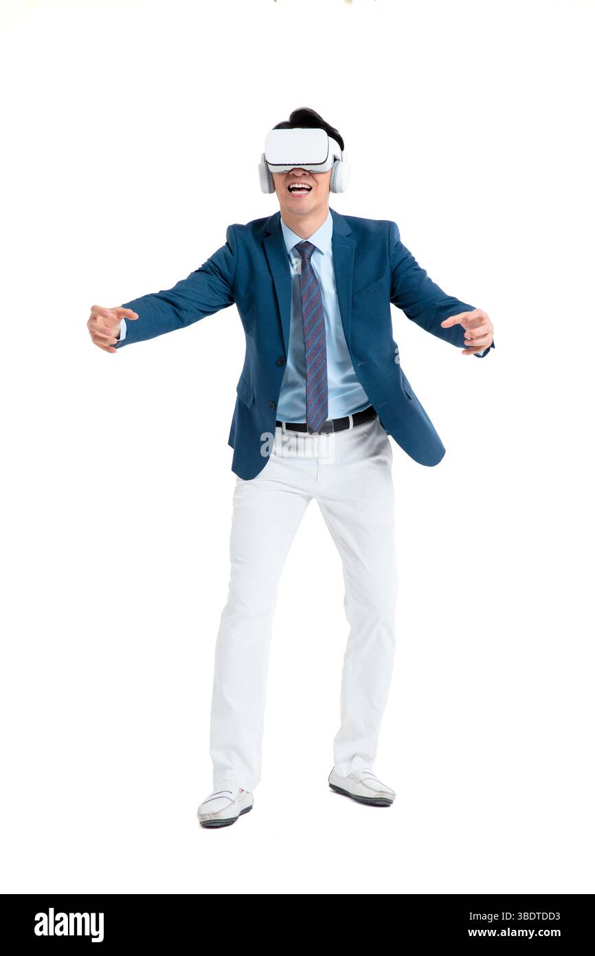 A suited businessman interacts with virtual objects through frenzied gestures, wearing VR/AR headset Stock Photo