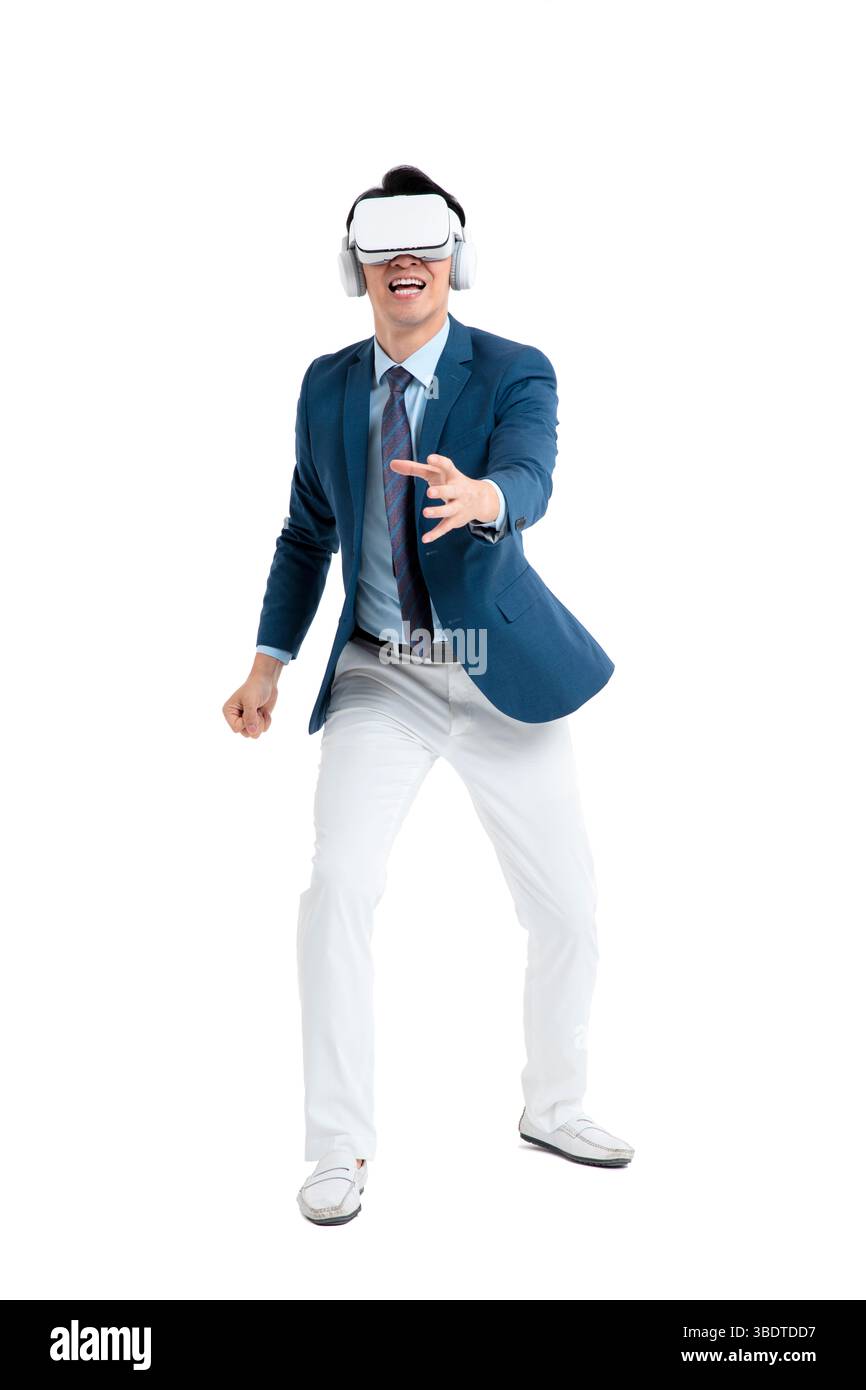 A suited businessman interacts with virtual objects through frenzied gestures, wearing VR/AR headset Stock Photo