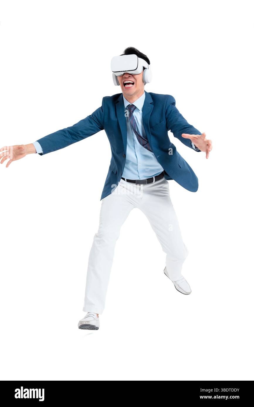 A suited businessman interacts with virtual objects through frenzied gestures, wearing VR/AR headset Stock Photo