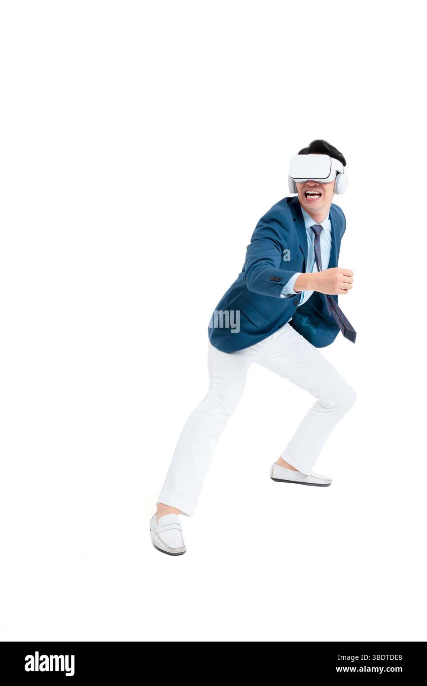 A suited businessman interacts with virtual objects through frenzied gestures, wearing VR/AR headset Stock Photo