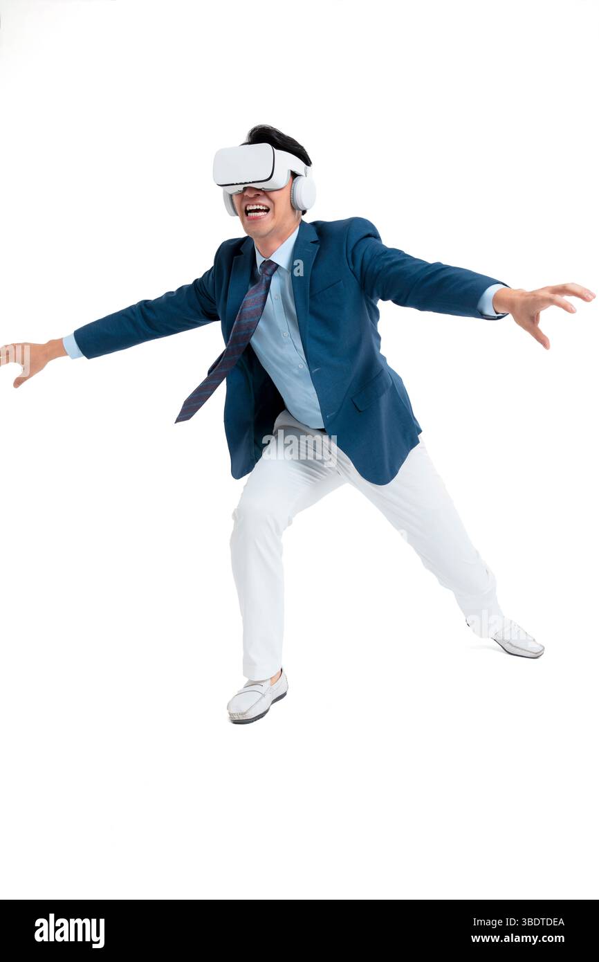 A suited businessman interacts with virtual objects through frenzied gestures, wearing VR/AR headset Stock Photo