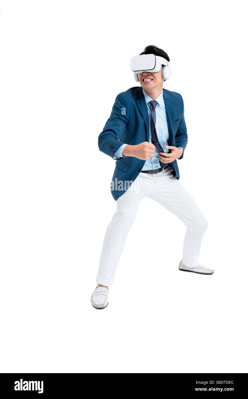 A suited businessman interacts with virtual objects through frenzied gestures, wearing VR/AR headset Stock Photo