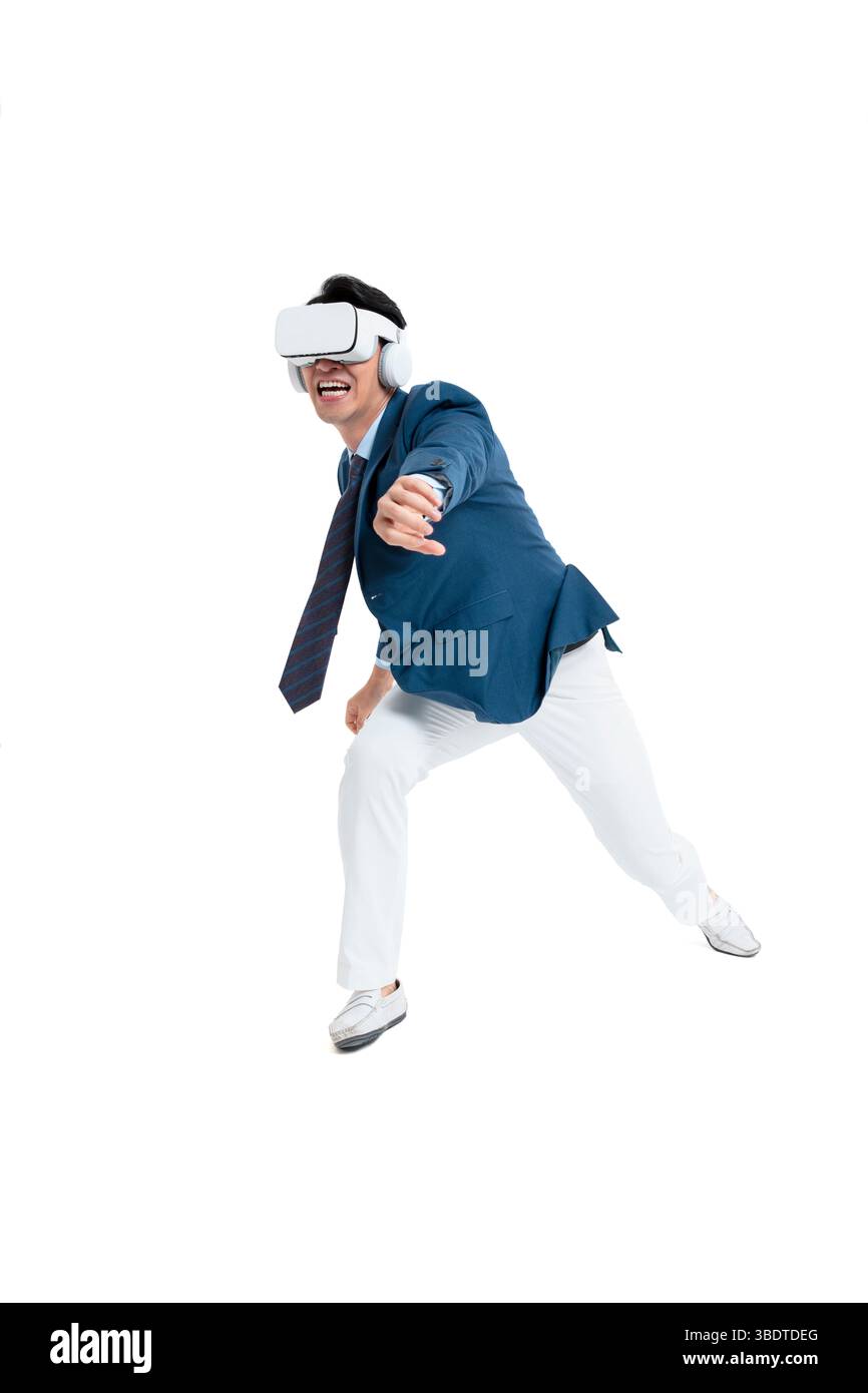 A suited businessman interacts with virtual objects through frenzied gestures, wearing VR/AR headset Stock Photo