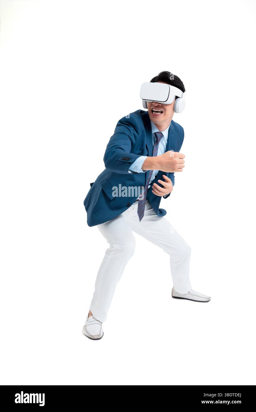 A suited businessman interacts with virtual objects through frenzied gestures, wearing VR/AR headset Stock Photo