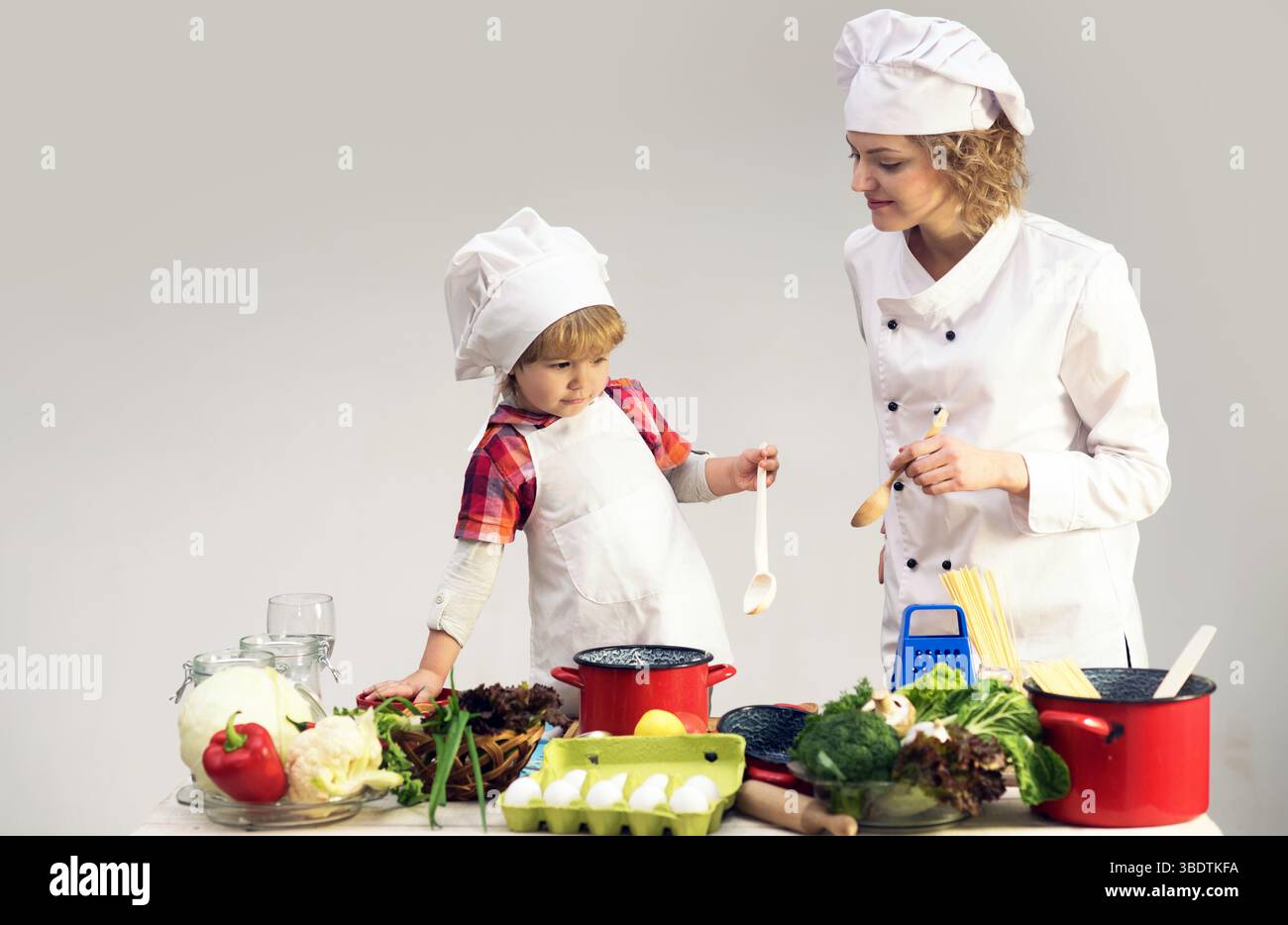 Mother and child cooking together. Kid baby helping mom to cooking in ...