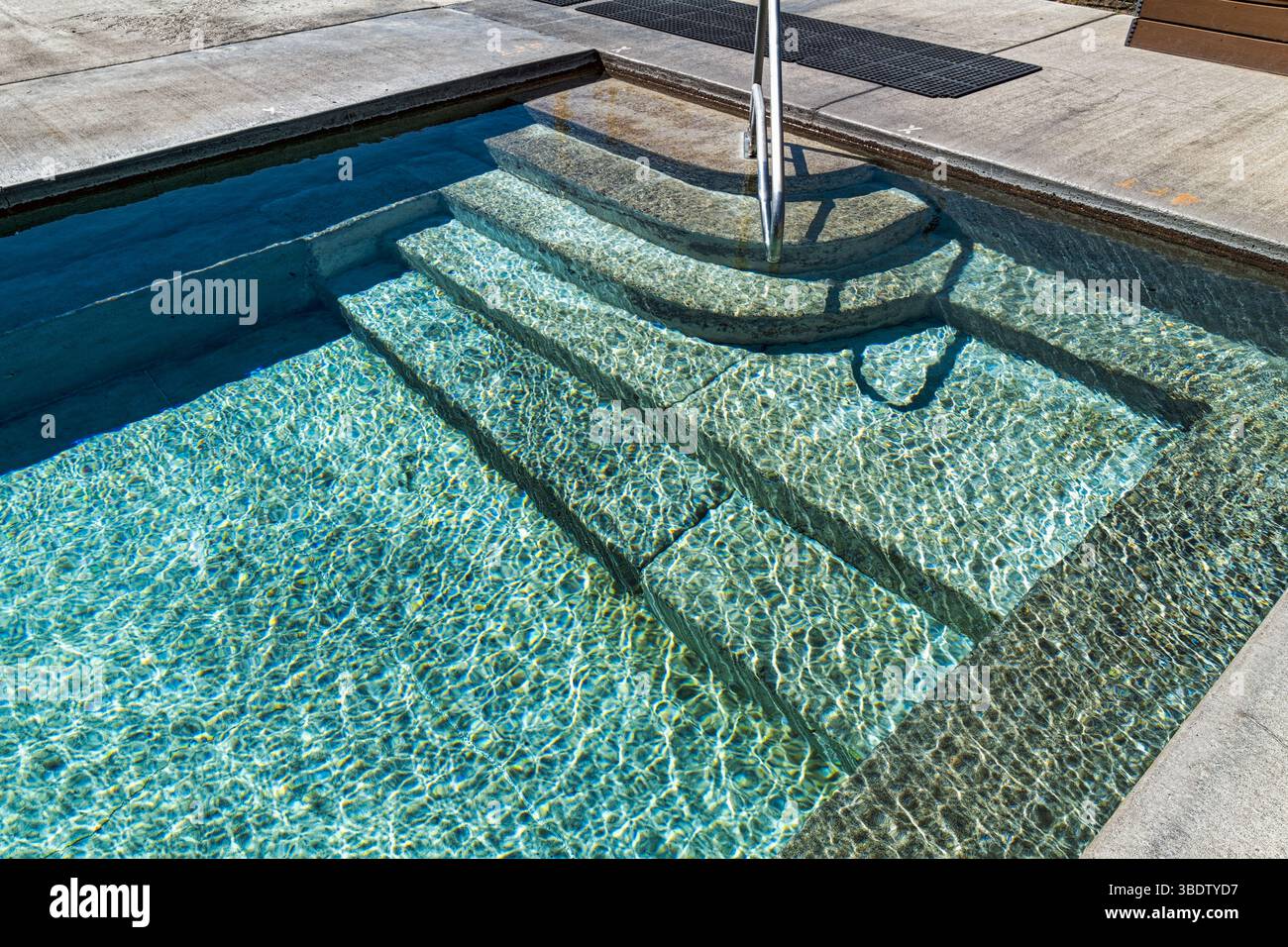 Steps leading gently into a shallow pool with rippled patterns on the water Stock Photo