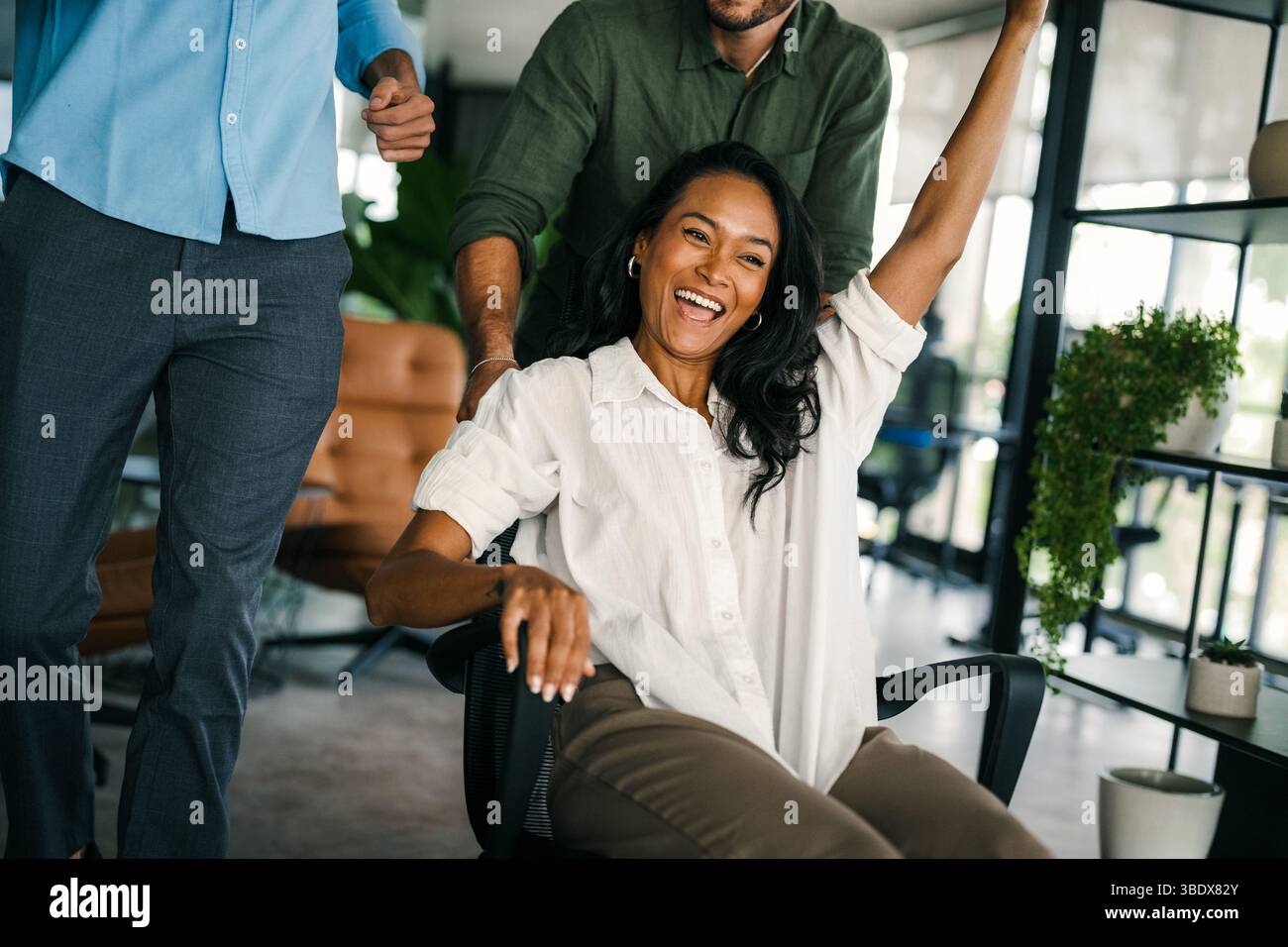 Excited diverse employees laughing enjoying funny activity at work break, creative friendly workers Stock Photo