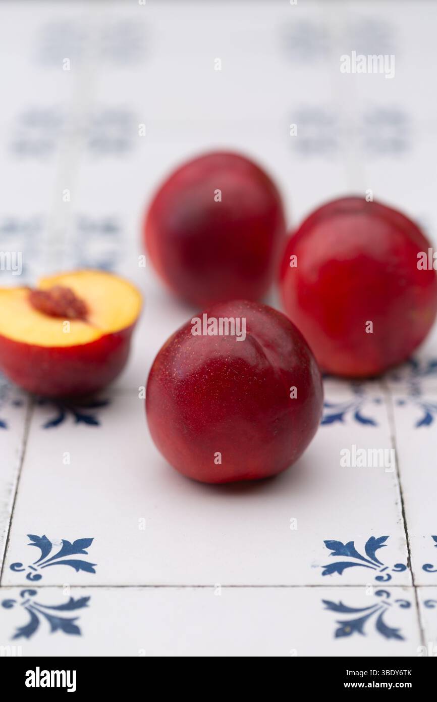 Shiny, ripe nectarines on white and blue tiles Stock Photo
