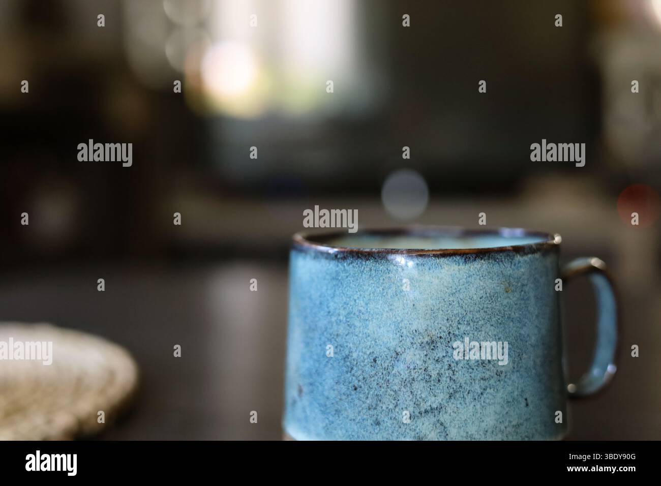 Beautiful handmade, turquoise ceramic mug on the dark wood table Stock Photo
