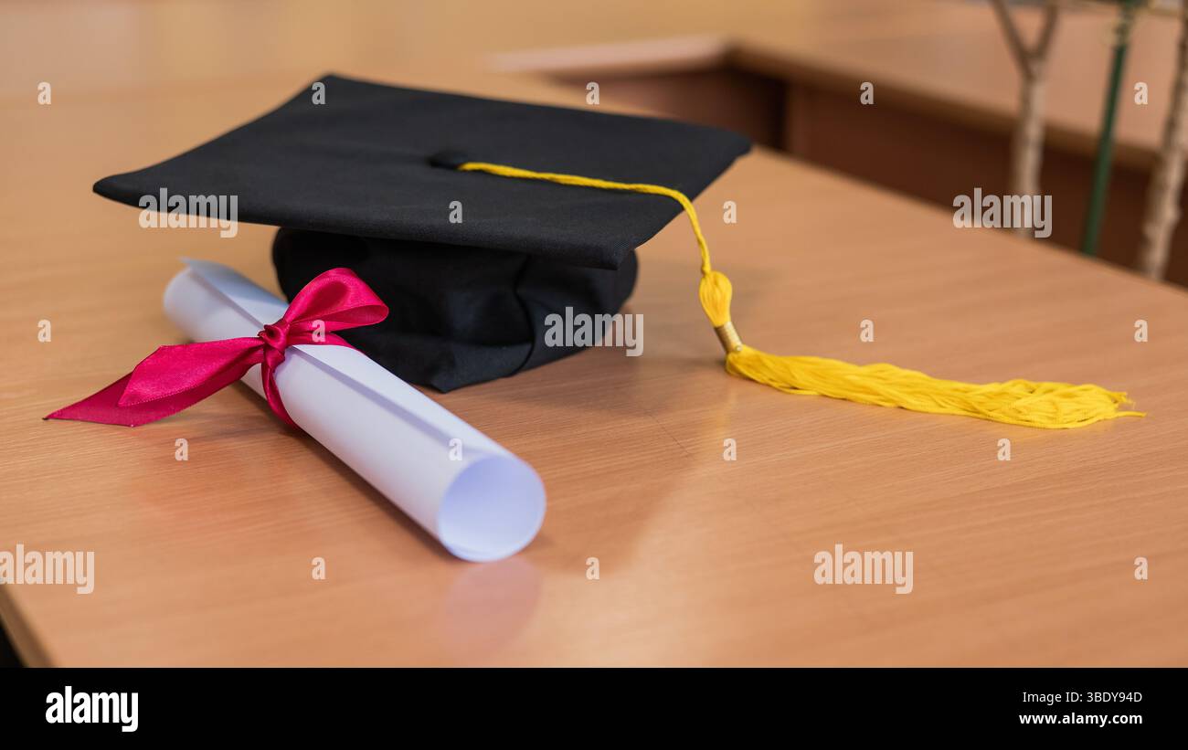 Graduation cap and diploma roll on the table Stock Photo - Alamy