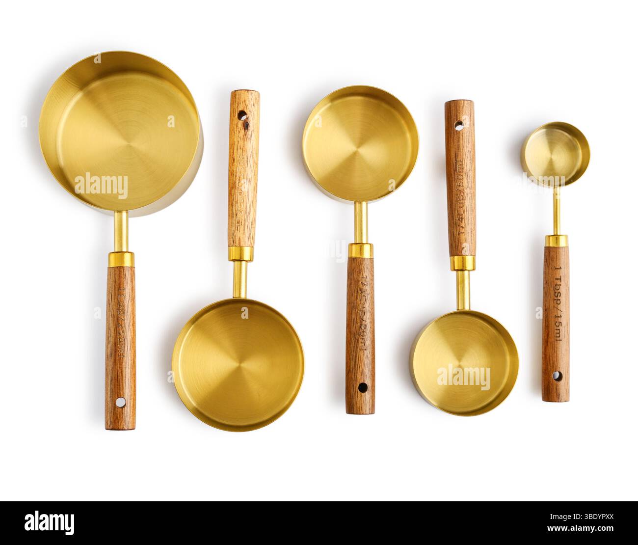 Golden measuring spoons with wooden handles isolated on white background Stock Photo