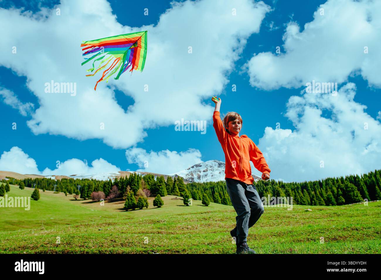 Happy boy with kite on mountains background Stock Photo