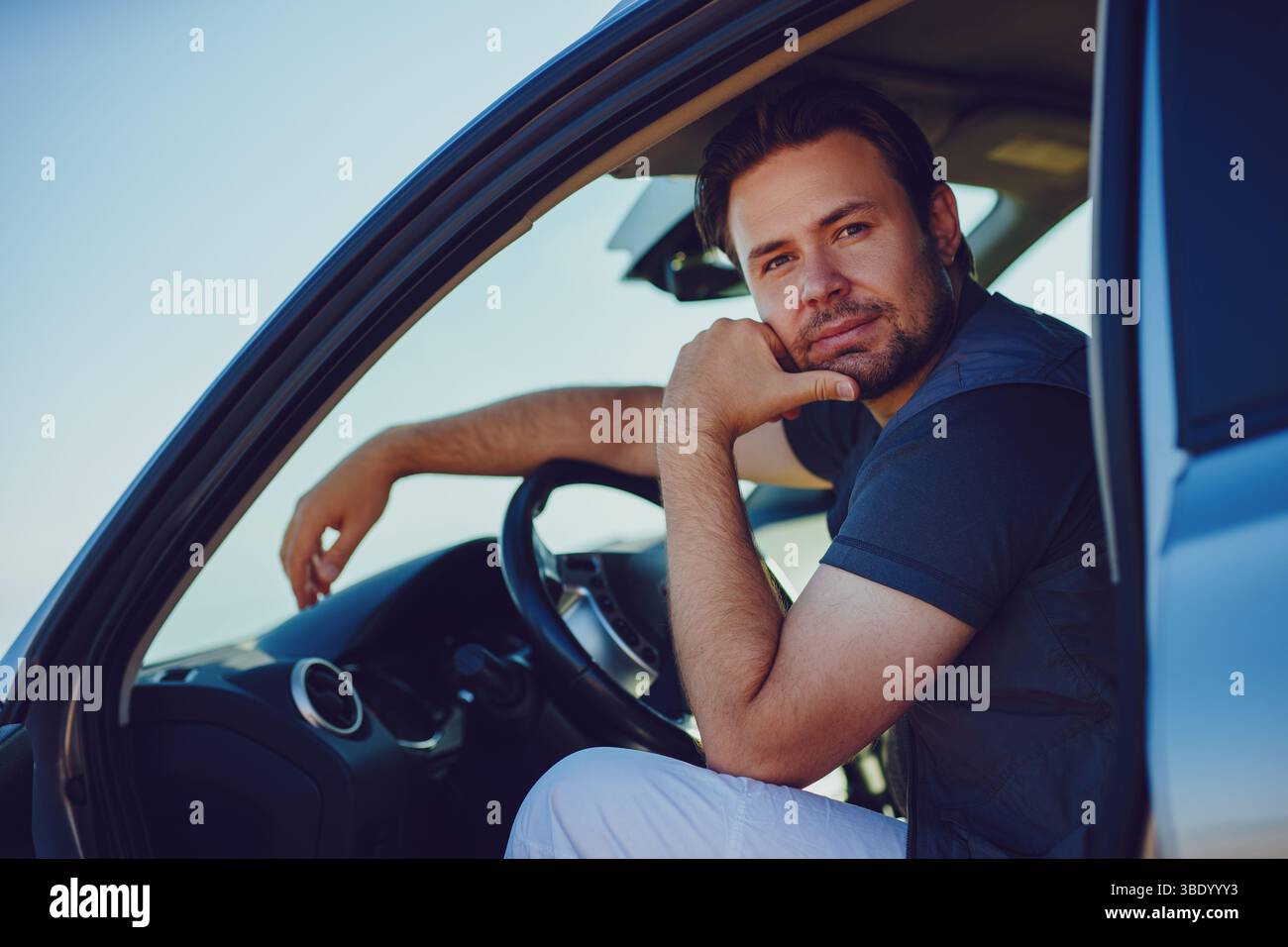 Handsome young pensive man sitting in car Stock Photo