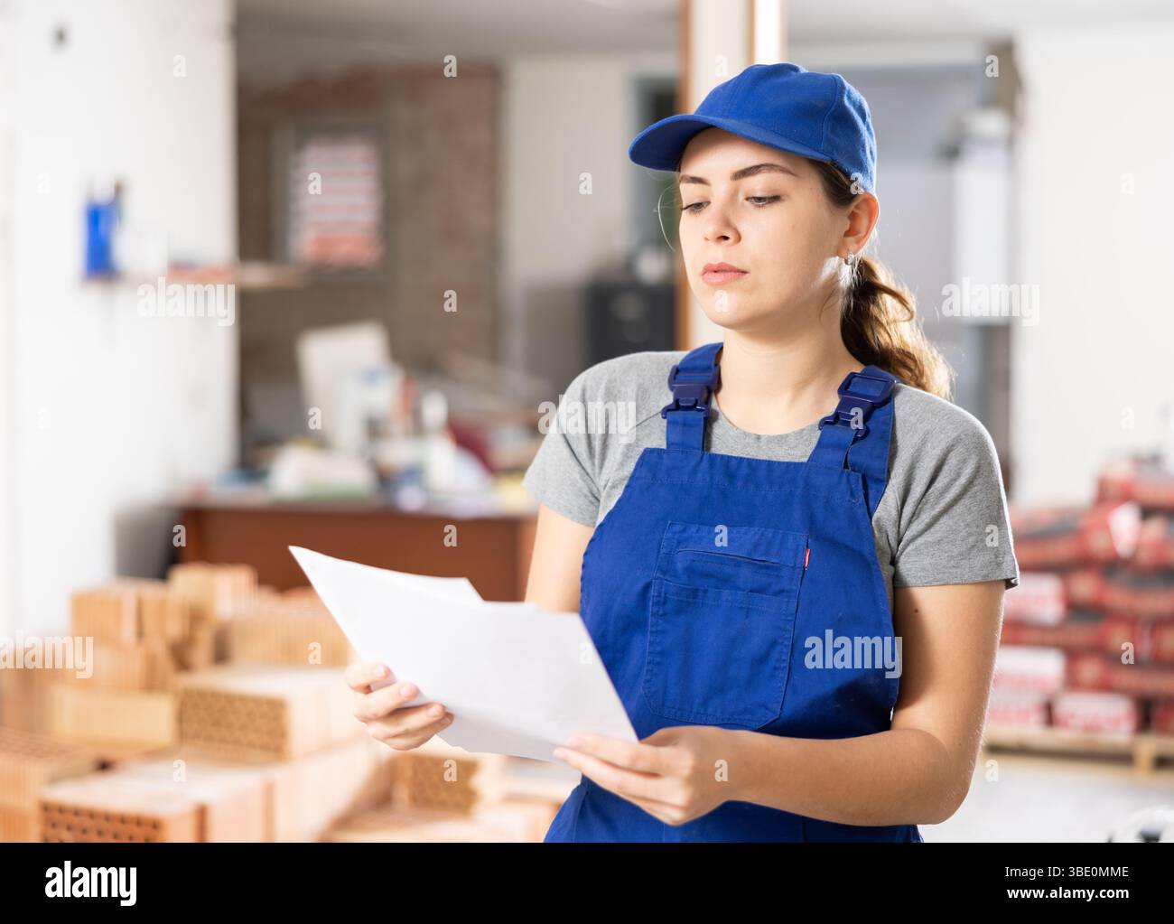 Female foreman making task list in building under construction Stock Photo