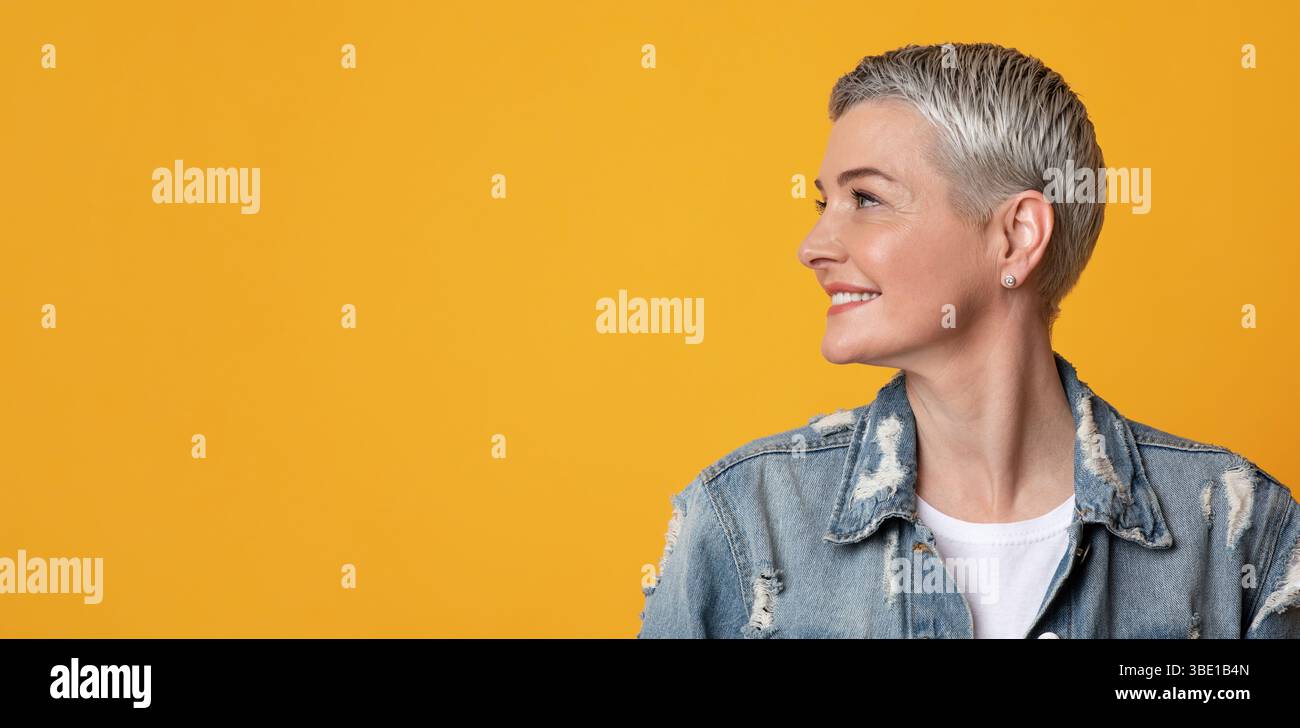Nice Promo. Smiling Mature Lady Looking With Interest At Copy Space Stock Photo