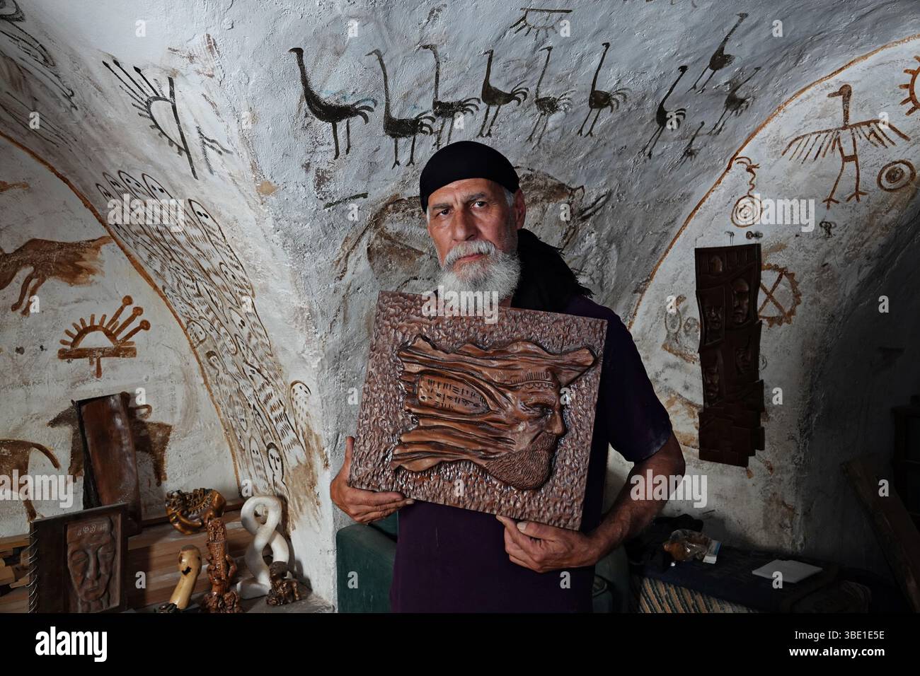 Sculptor Akram Saffan is seen with his work, which describes a man ...