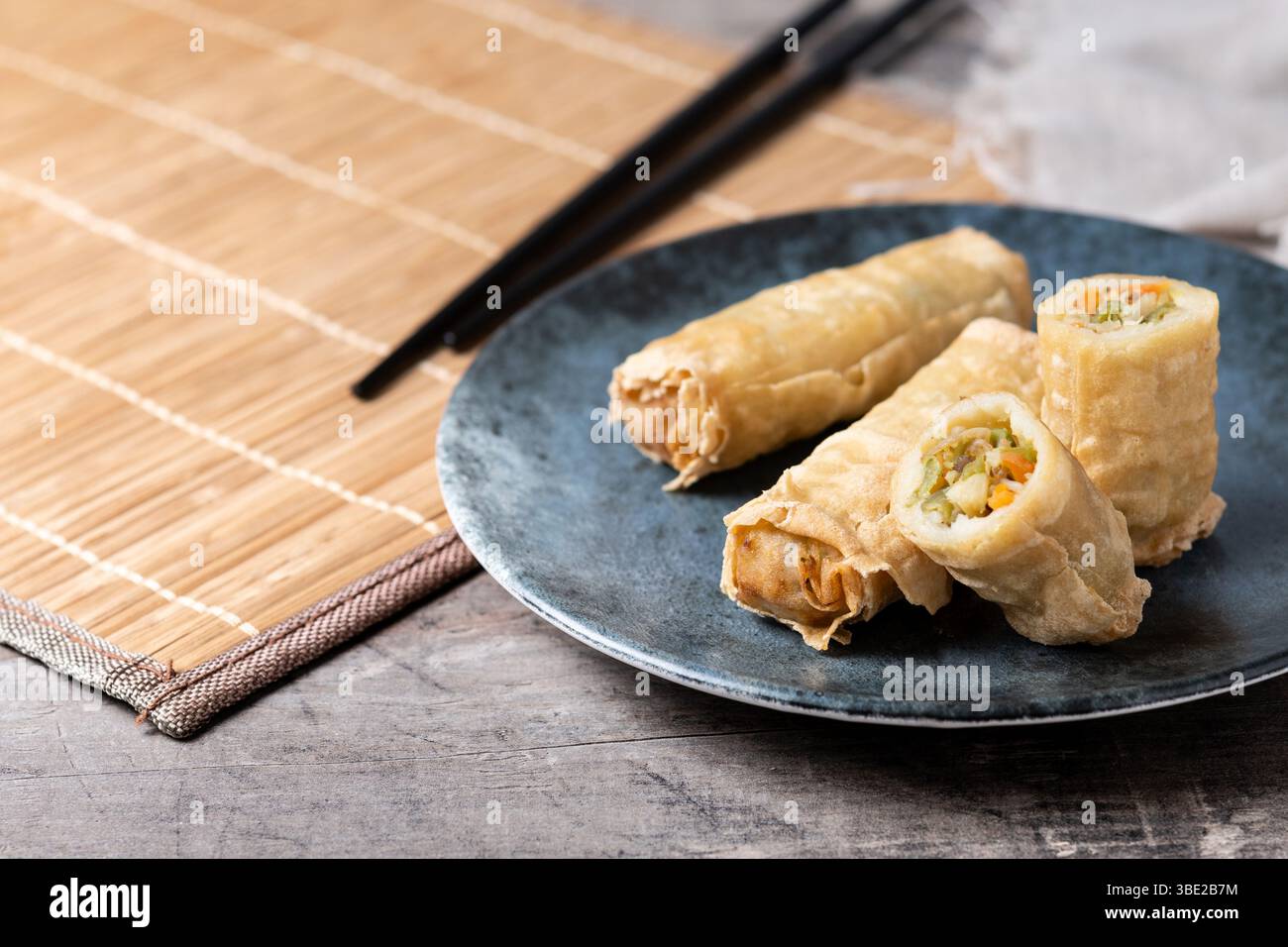 Crispy Spring Rolls on Ceramic Plate on wooden table Stock Photo