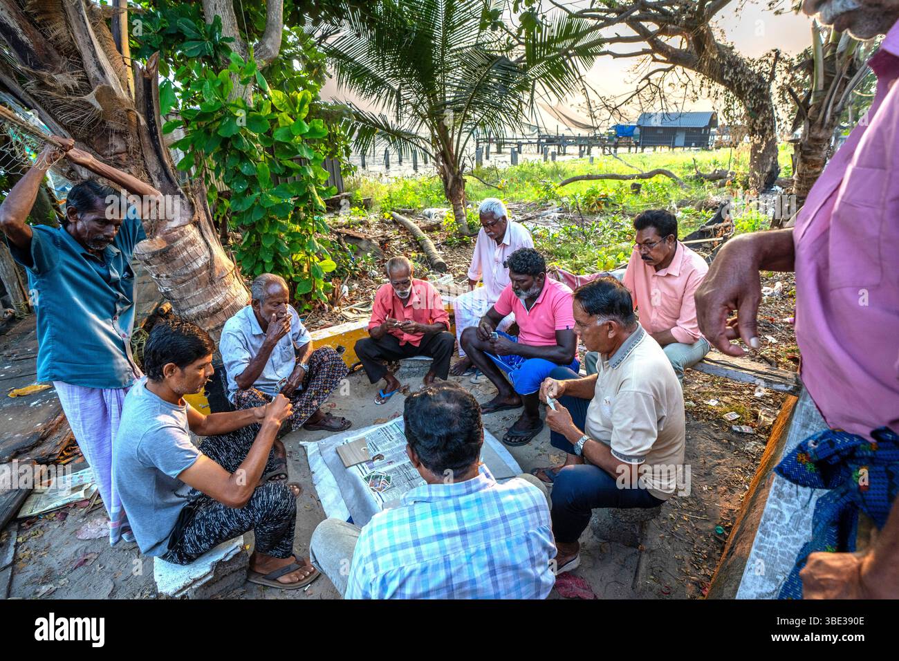 India, Kerala, Kochi, fishermen playing cards Stock Photo