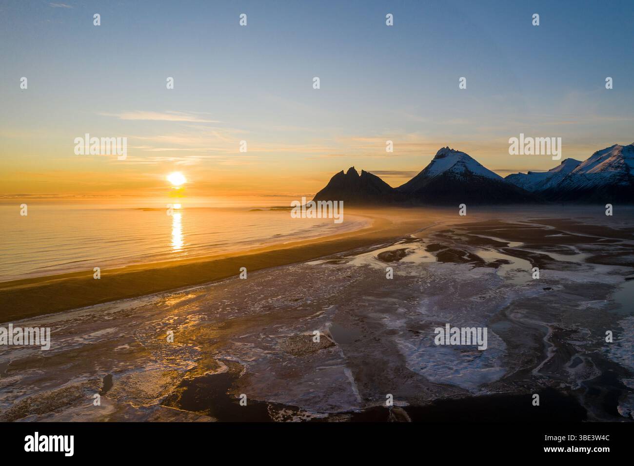 Golden sunrise over Brunnhorn mountain and frozen beach, East Iceland. Stock Photo