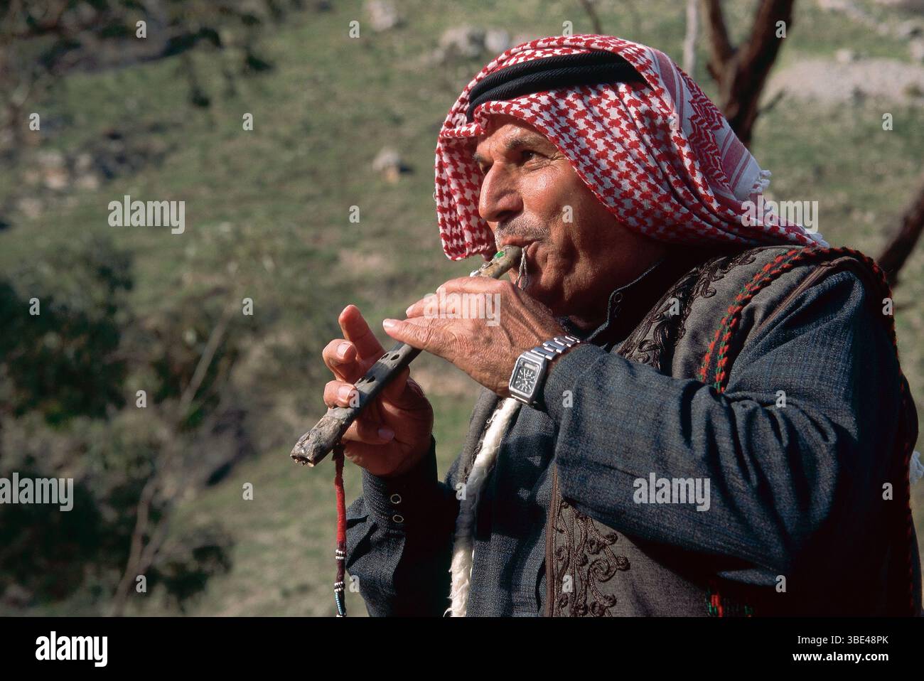 Mature Bedouin man plays a flute made of a bone of a griffon vulture Stock Photo
