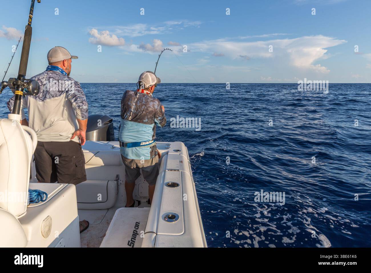 Offshore fisherman reeling in a fish in the Gulf of Mexico Stock Photo