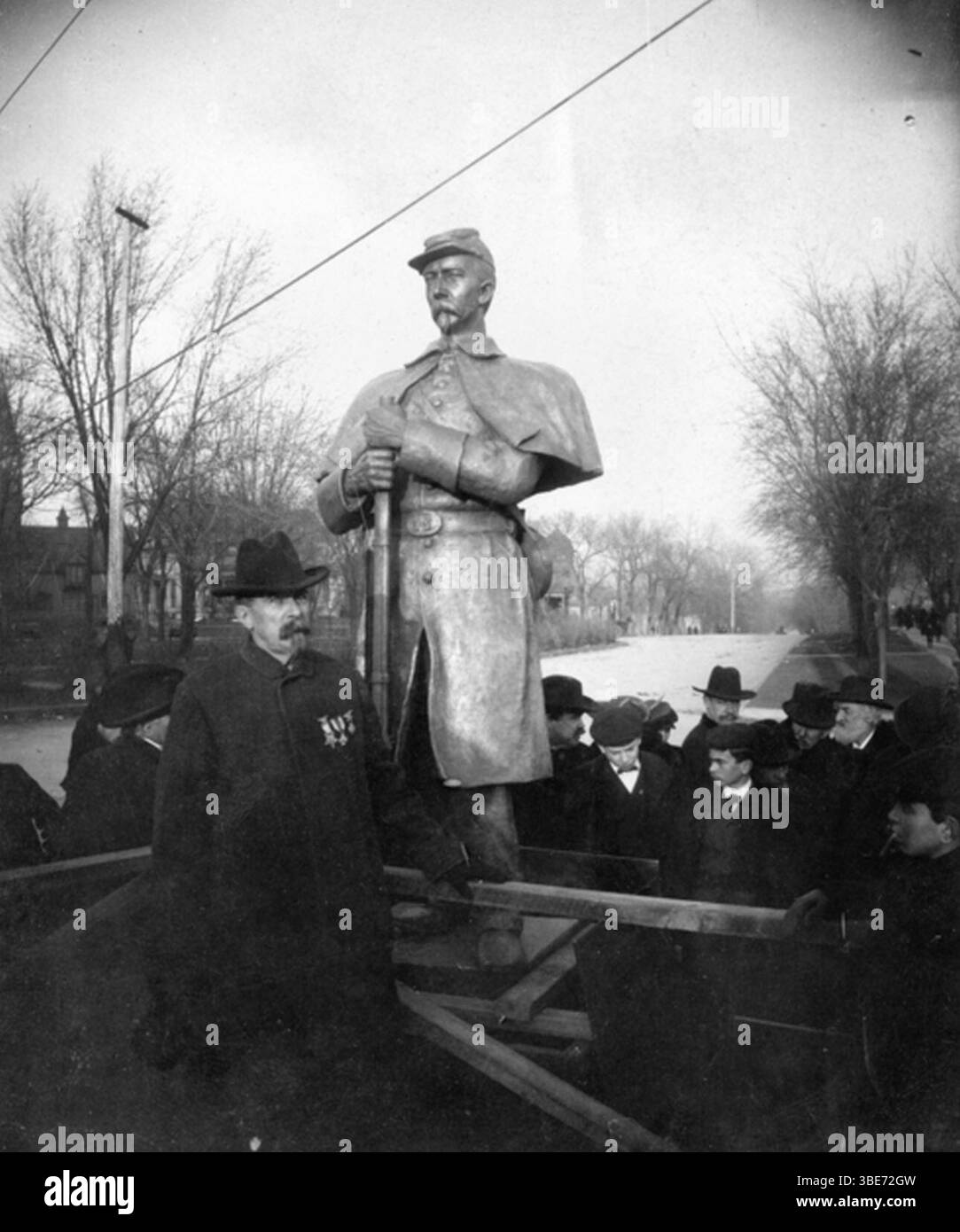 Josias R. King standing in front of the bronze statue of the Soldiers ...