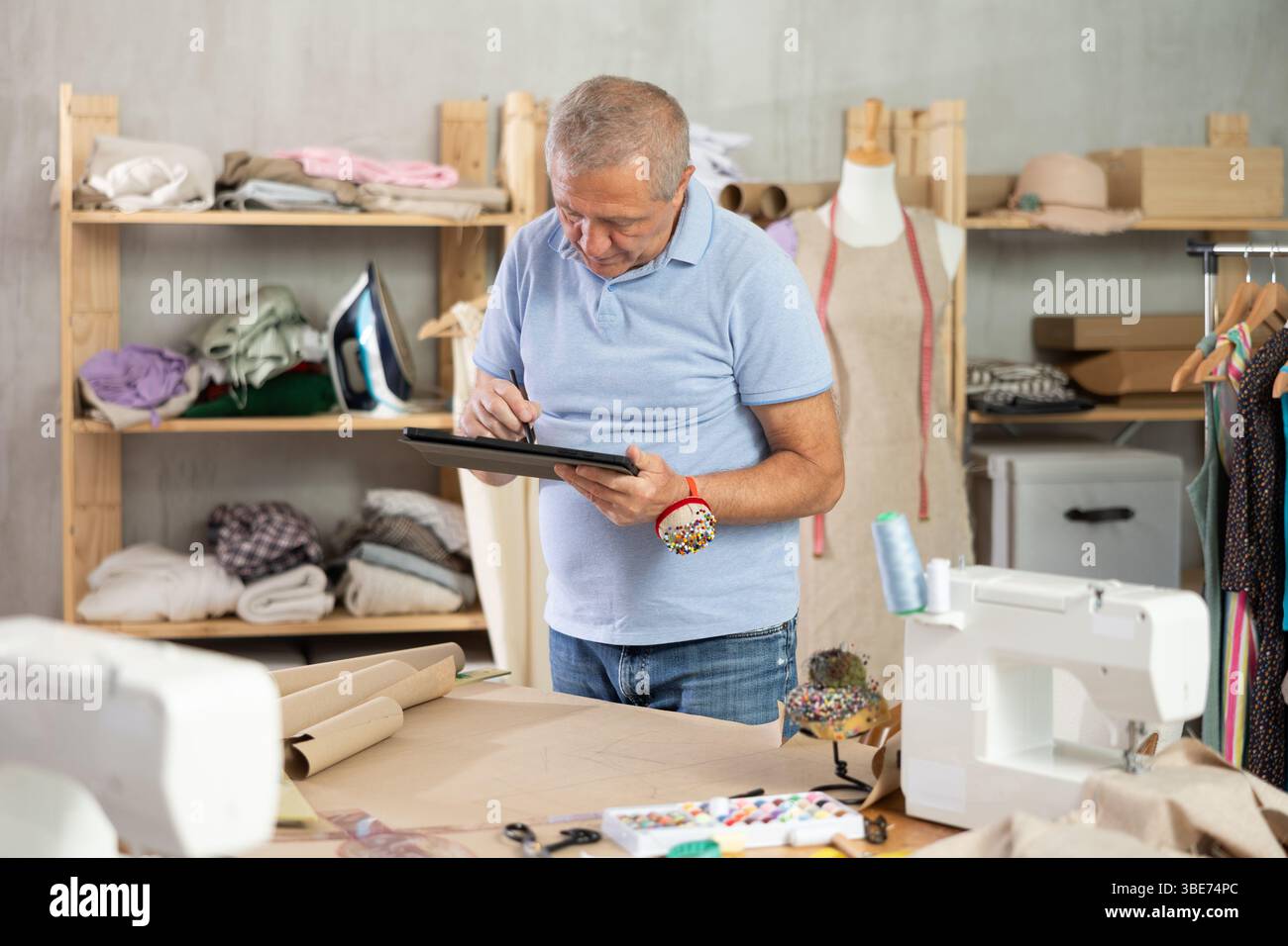Man tailor makes pattern using tablet Stock Photo