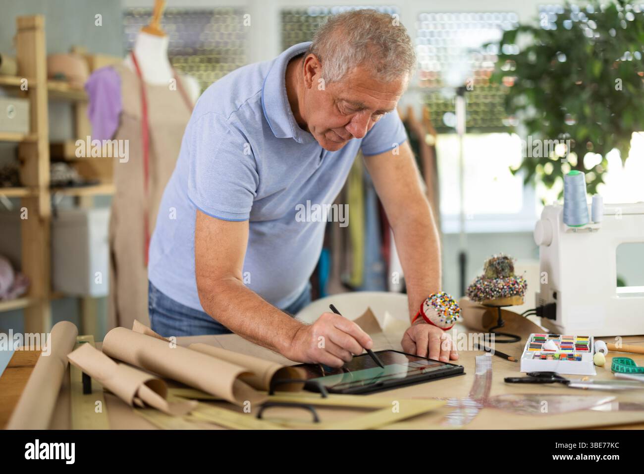 Man tailor makes pattern using tablet Stock Photo