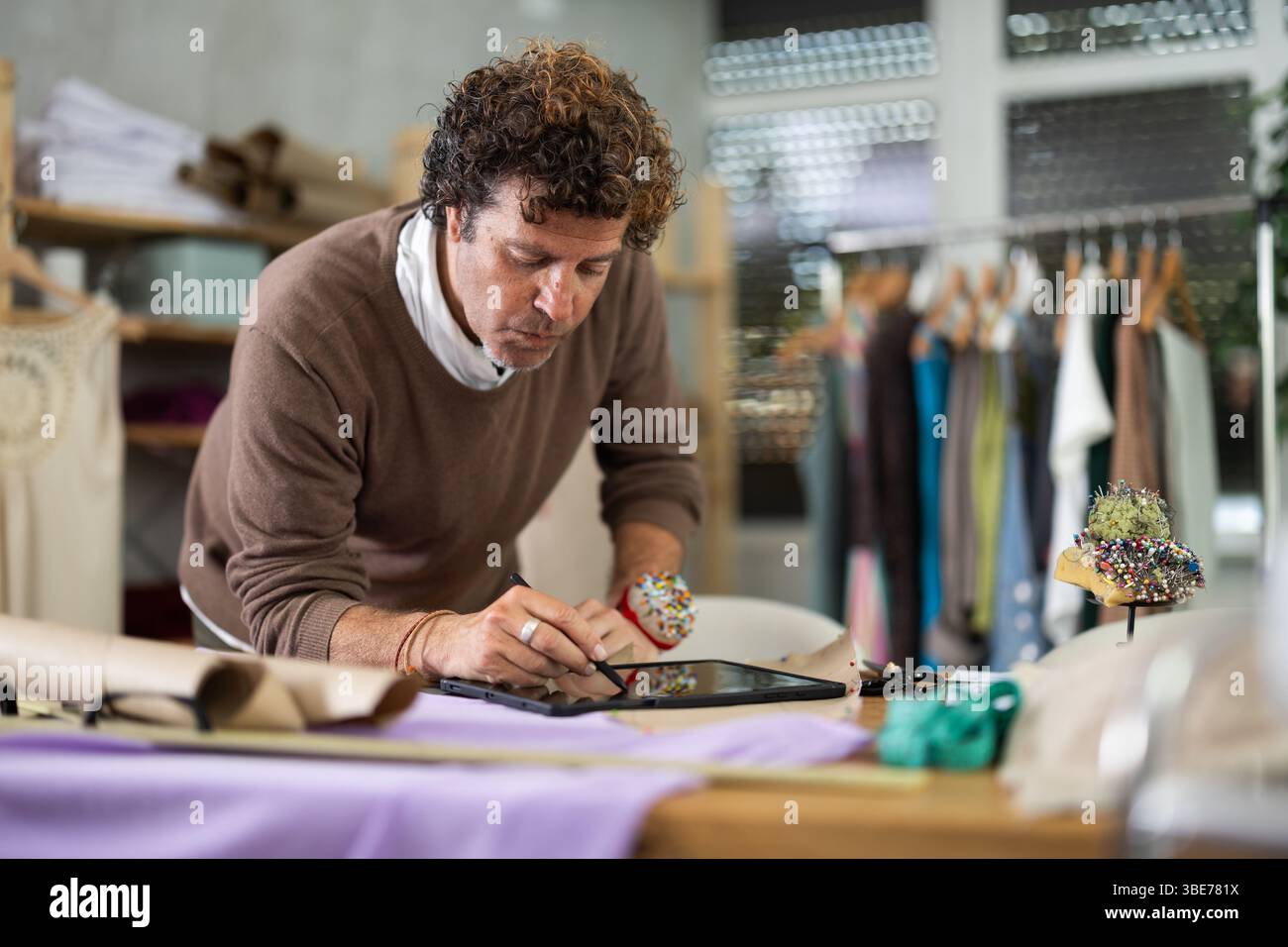 Man tailor makes pattern using tablet Stock Photo