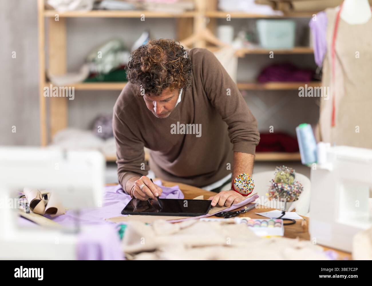 Man tailor makes pattern using tablet Stock Photo
