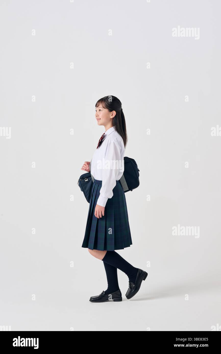Japanese Junior High School Girl with Schoolbag on White Background Stock Photo