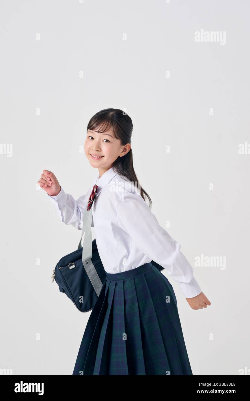Japanese Junior High School Girl with Schoolbag on White Background Stock Photo