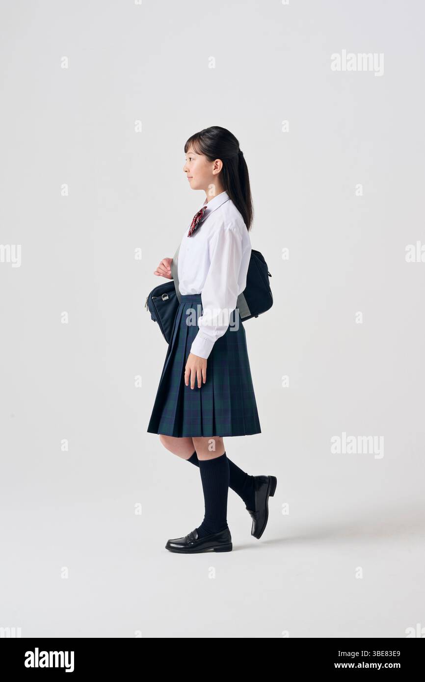 Japanese Junior High School Girl with Schoolbag on White Background Stock Photo
