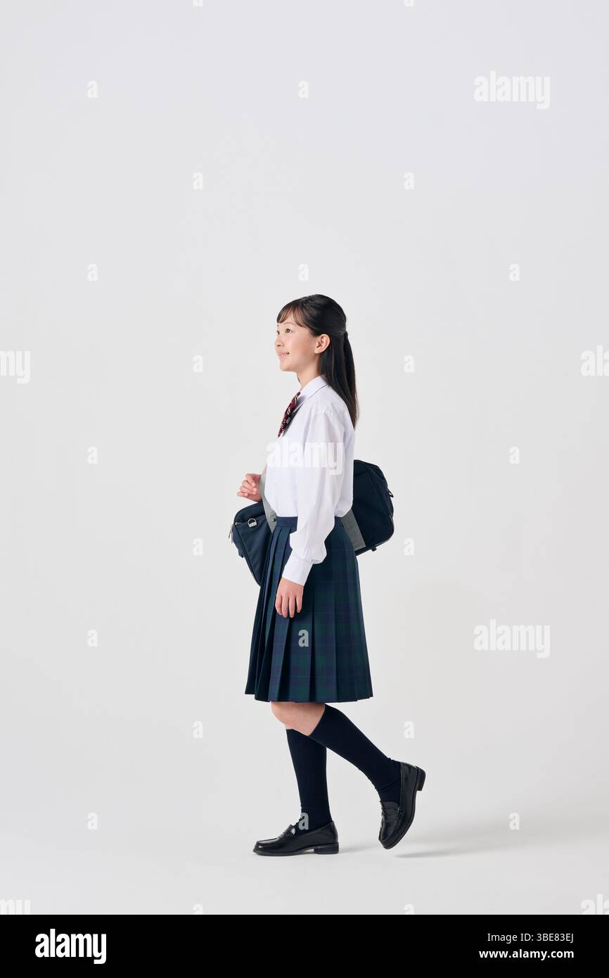 Japanese Junior High School Girl with Schoolbag on White Background Stock Photo