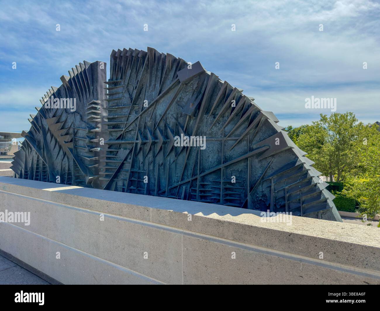 Abstrakte Metallskulptur auf moderner Terrasse unter blauem Himmel - Smartphone Captured Stock Image