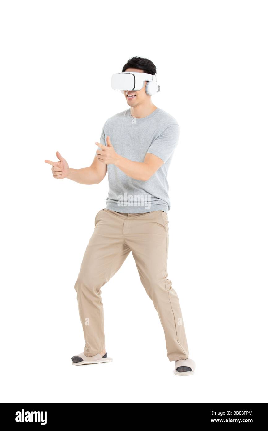 A young man wearing a VR headset, engaged in immersive human-machine interaction Stock Photo