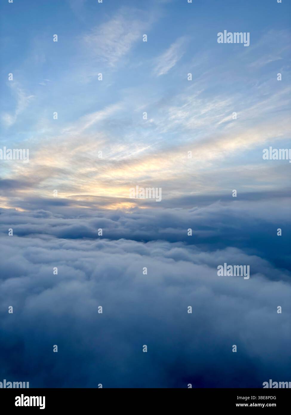 Scenic view of dramatic cloudscape and soft sunlight at high altitude, taken from an airplane. - Smartphone Captured Stock Image