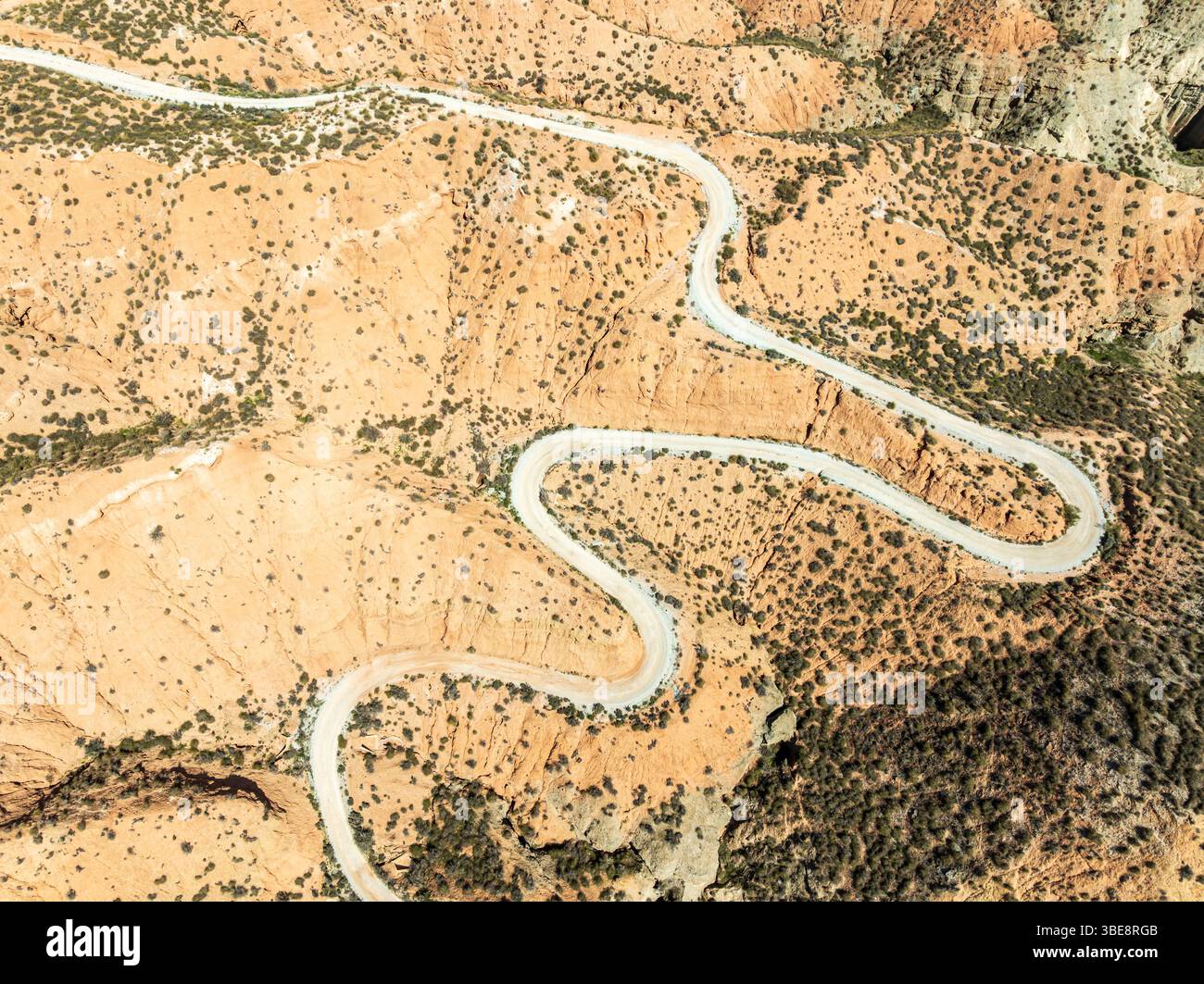 Winding road in the desert, surrounded by colorful canyons and gorges, aerial view, Gorafe Desert, UNESCO Granada Geopark, Granada province, Andalusia Stock Photo
