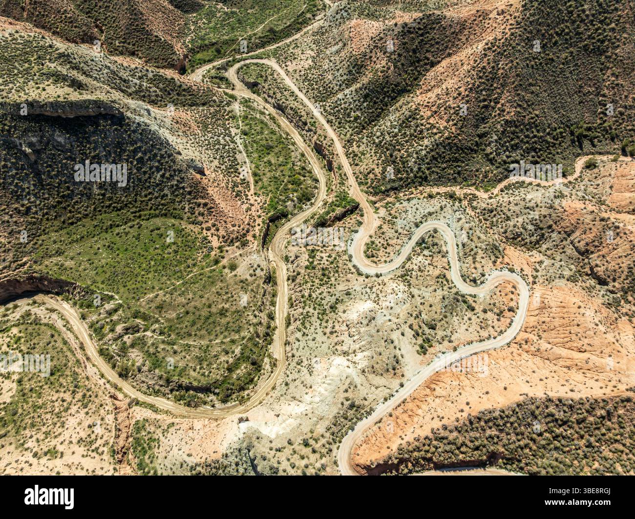 Winding road in the desert, surrounded by colorful canyons and gorges, aerial view, Gorafe Desert, UNESCO Granada Geopark, Granada province, Andalusia Stock Photo