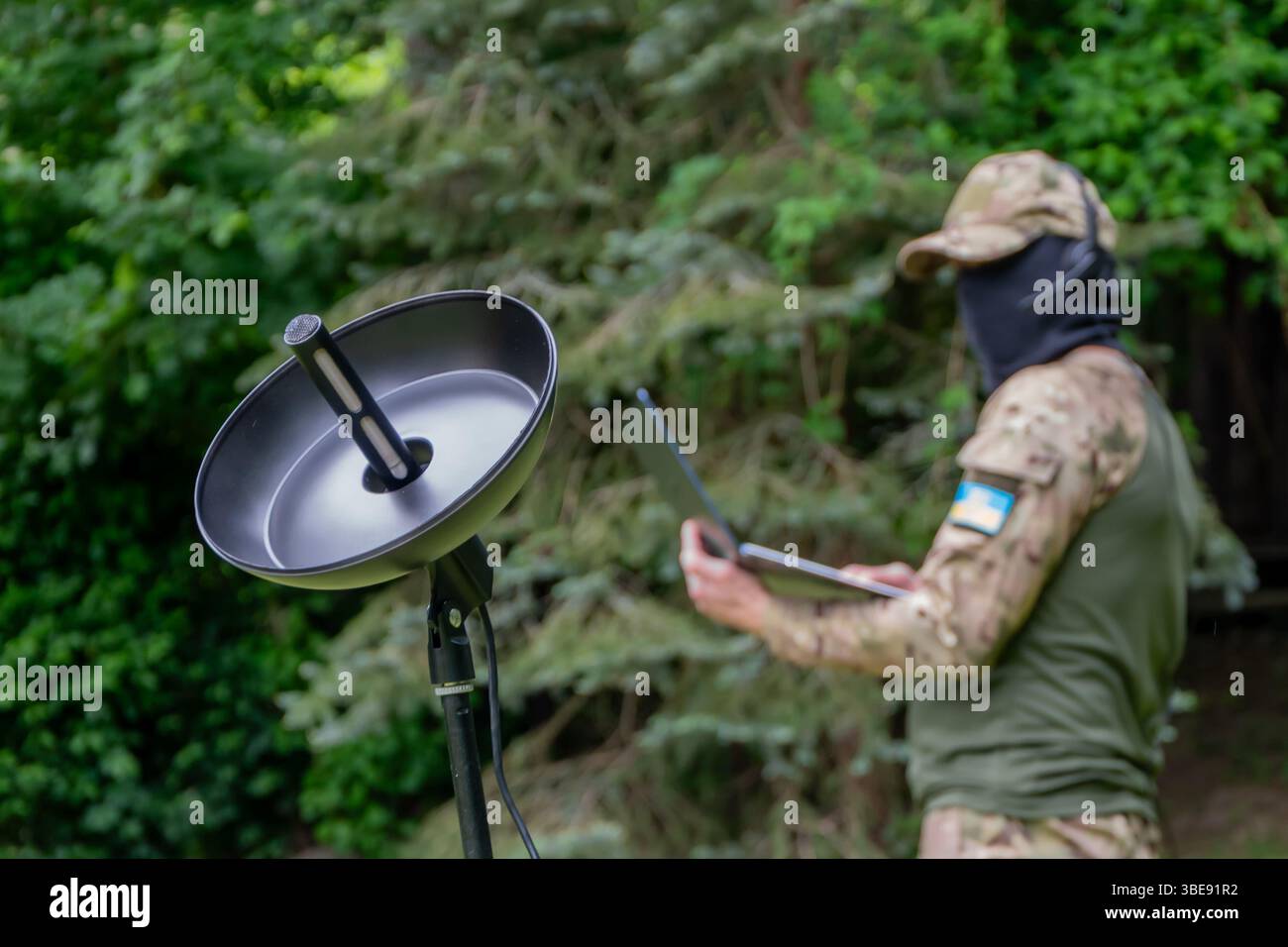 A Ukrainian military specialist analyses data from a directional microphone Stock Photo