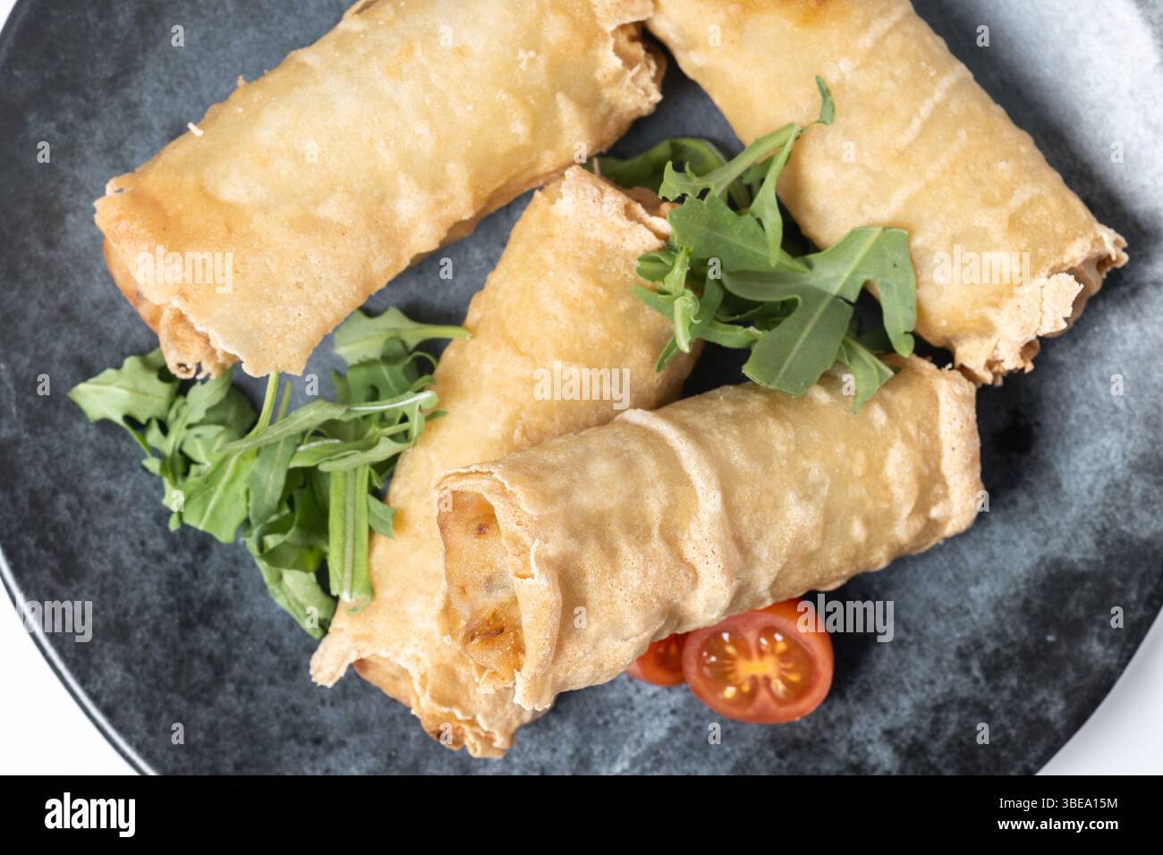 Crispy vegetables spring Rolls on Ceramic Plate isolated on white background Stock Photo