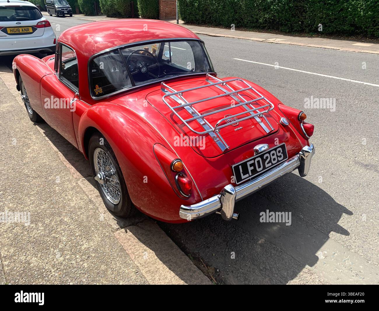 MG MGA red sports car bright British old classic posh old style Northampton Park Avenue UK shinny rear front side famous cars silver bumper - Smartphone Captured Stock Image