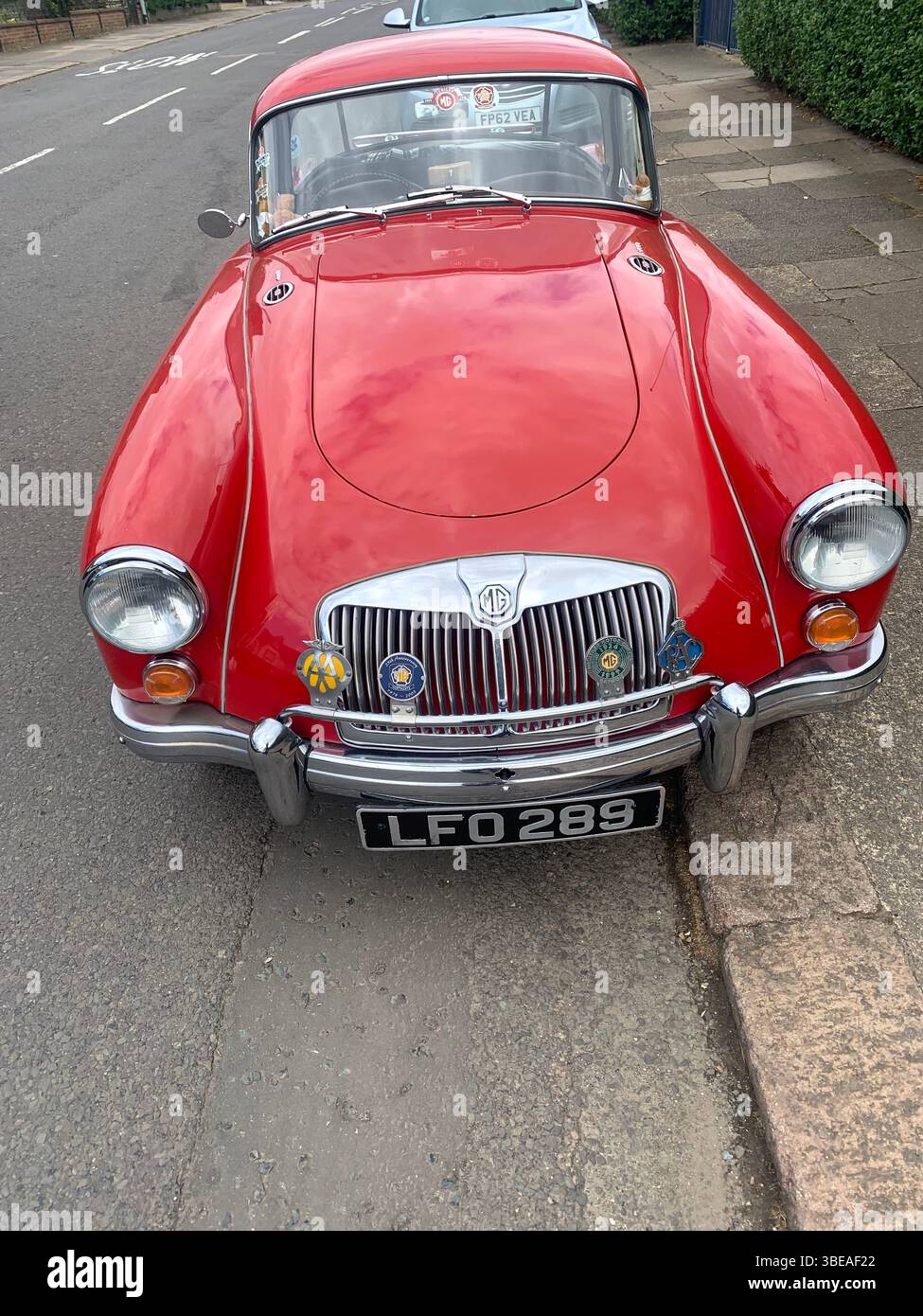 MG MGA red sports car bright British old classic posh old style Northampton Park Avenue UK shinny rear front side famous cars silver bumper - Smartphone Captured Stock Image